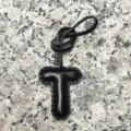 Black leather letter T bag charm detail showcasing fine stitching and smooth texture. - Uppercase Letter T / Black