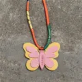 Vista detallada del colgante de bolso mariposa de minicuero con cinta de seda de colores. - Rosa Y Amarillo