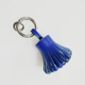 Detailed view of blue genuine sheepskin leather tassel keychain and stylish bag charm accessory. - Blue