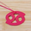 Detailansicht des rosafarbenen Leder Sternzeichen Krebs Taschenanhängers mit Riemen. - Fuchsia