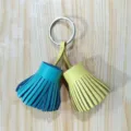 Close-up detail of the colorful leather tassel keychain and bag charm ornament pendant. - Peacock Blue and Yellow