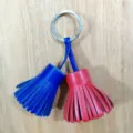 Detailed view of the dual-color leather tassel keychain, showing blue and red tassels. - Royal Blue and Red