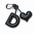 Black leather letter D and heart bag charm detail close-up view showing exquisite stitching - Black with Black Heart