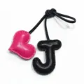 Dettaglio del ciondolo in pelle fatta a mano con lettera J e cuore rosa per borse e auto. - Nero e Rosa Rosso
