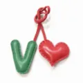 Detalle de dije de bolso letra V de cuero y corazón rojo, elegante colgante hecho a mano. - V Verde con Corazón Rojo Brillante