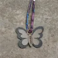 Vista detallada del lindo colgante de bolso de mariposa de cuero con cinta colorida. - Caqui Y Negro