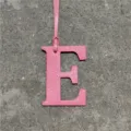 Pink leather letter E bag charm close-up detail, stylish alphabet accessory for handbags - Pink