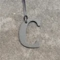 Grey leather letter C bag charm detail shot, stylish handbag pendant accessory with strap. - Gray