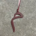 Leather bag charm detail showing fine grained texture and neat edge stitching finish. - Burgundy