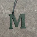 Leather letter M bag charm close up detail view green texture accessory decorative item - Dark Green