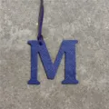 Blue leather letter M bag charm detail view, elegant initial charm for handbags and car keychains. - Sapphire Blue