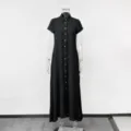 Vista dettagliata di un abito camicia nero a maniche corte, colletto a risvolto e bottoni. - Taglia S / Nero