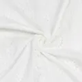 Gros plan sur le tissu en coton blanc pur brodé de délicats motifs ajourés circulaires. - S / Blanc