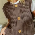 Chunky knit sleeveless cardigan vest detail, brown ribbed fabric with large gold buttons. - Khaki