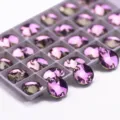 Close-up detail of round purple sew-on glass crystals in organizer tray for DIY clothing crafts. - 12mm 40 Pieces/Pack / 53 Light Purple Rose Red