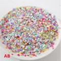 Primer plano de lentejuelas de corazón láser coloridas en plato blanco, accesorio de joyería DIY. - Multicolor