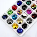 Close-up detail of multi-color pointed back crystal rhinestones in white tray, sparkly loose stones. - Random Mixed Colors