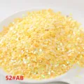 Detalle en primer plano de lentejuelas de corazón amarillo, ideales para accesorios de ropa. - Amarillo AB