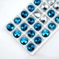 Detail shot of sparkling pointed-back glass rhinestones in blue and silver for crafts and DIY jewelry. - 6mm 84pcs/pack / Lake Blue