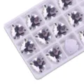 Nahaufnahme von dreieckigen flachen zum Aufnähen Strasssteinen in Box, funkelndes Kristall. - 12mm 28 Stück/Packung / 01 Weiß