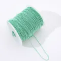 Close-up of mint green ball bead chain roll on spool, perfect for DIY crafts and nail decor. - Light Green