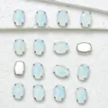Close-up detail of oval iridescent glass rhinestones with metal claw settings for DIY crafts. - 10x14mm 20 Pcs/Pack / 46 Crystal Opal Mocha