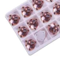 Detail view of champagne pink fat triangle glass sew-on rhinestones in tray, ideal for DIY crafts. - 13 Watermelon Red