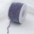 Close-up view of a gradient purple rhinestone chain spool for DIY crafts and apparel. - Light Purple Glow