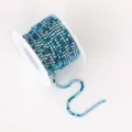 Close-up detail of a blue rhinestone cup chain wrapped on a spool, perfect for DIY crafts. - SS6 2mm 10 Yards/9m/Roll / Mixed Light Blue Rhinestones with Matching Base