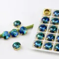 Nahaufnahme von glänzenden 12mm blauen Farbverlauf Strasssteinen mit Goldkrallen für Handwerk. - 10 Stück/Packung / Blaugrüner Farbverlauf