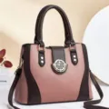 Detailed view of the pink and brown contrast handbag featuring premium textured leather material. - Pink