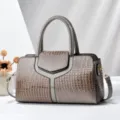 Elegante handtas van lakleer met krokodillenprint, handvat en stijlvolle schouderriem voor dames. - Grijs