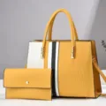 Detailgezicht van de colorblock handtassenset met bijpassende clutch en gouden details. - Aardgeel