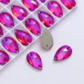 Close-up of pink drop-shaped crystal rhinestones with dual holes for DIY sewing and crafts. - Big Red AB