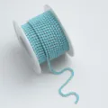 Nahaufnahme einer hellblauen Strasskrallenkette auf weißer Spule für DIY-Bastelarbeiten. - SS6 (1 Yard/Packung) / Fluoreszierendes Seeblau AB