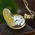 Gouden zakhorloge detailweergave met witte wijzerplaat, zwarte cijfers en DAD deksel. - Brons
