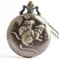 Close-up view of vintage bronze pocket watch featuring detailed zodiac rat and grape relief. - Rat Zodiac