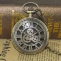 Vintage bronzen mechanische zakhorloge met holle Romeinse cijfers en zichtbare tandwielen. - Brons