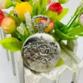 Antike silberne Taschenuhr mit filigranem geprägten Rosen-Blumenmuster und dekorativem Anhänger. - Silber