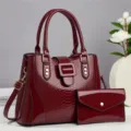 Elegante bordeauxkleurige lakleren handtassen set met schouderriem en bijpassende clutch. - Bordeauxrood