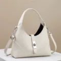 Witte lederen schoudertas met metalen sluiting, stijlvolle crossbody handtas voor dames. - Wit