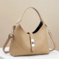 Elegante beige lederen schoudertas met metalen sluiting en veelzijdige crossbodyriem. - Khaki