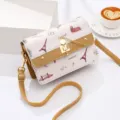 Modieuze kleine dames schoudertas met een schattige kattensluiting en leuk reismotief. - Geel