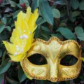 Detalle de máscara veneciana dorada con plumas amarillas, perlas y diamantes para fiesta. - Talla única / Amarillo
