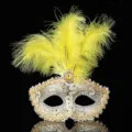 Detailansicht der venezianischen Maske mit gelben Federn, Goldspitze und glänzenden Strasssteinen. - Gelb