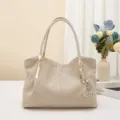 Elegante borsa a tracolla trapuntata grigia da donna con dettagli dorati e ciondolo chic. - Albicocca