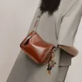 Borsa a tracolla vintage da donna marrone con tracolla fantasia e ciondolo per lavoro. - Marrone