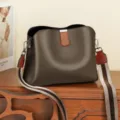 Elegante borsa a secchiello in vera pelle marrone con tracolla a contrasto chic da donna. - Caffè