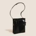 Borsa a tracolla in pelle verniciata nera con forma quadrata strutturata e nodo da cintura. - Nero