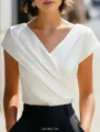 Detail view of the elegant white cross V-neck short sleeve top showing smooth fabric texture. - S / White